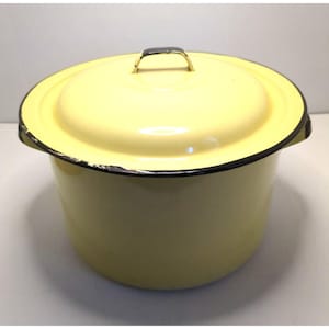 May include: A round, pale yellow enamel stockpot with a matching lid. The pot features a dark rim around the top edge and a small metal handle on the lid. The exterior surface is smooth and solid yellow, showing minor wear along the dark rim.