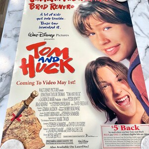 Può includere: Un poster cinematografico vintage del film Disney "Tom and Huck" con Jonathan Taylor Thomas e Brad Renfro. Il poster presenta un'illustrazione di mappa del tesoro e il testo "Coming to Video May 1st!"