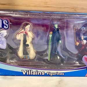 Puede incluir: Un juego de figuras de Disney Villanos en caja. El juego incluye a Úrsula, Cruella de Vil, Maléfica y el Capitán Garfio. La caja es azul y morada con la palabra "Villains" en blanco. El logotipo de Disney es visible.