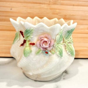 Könnte beinhalten: Eine weiße Keramik-Tasse mit schwarzem Henkel und dem Text "But First, Coffee" in schwarzer, fetter Schrift. Die Tasse ist etwa 10 cm hoch und fasst ca. 350 ml Flüssigkeit.