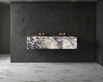 May include: A modern bathroom design featuring a floating marble vanity with gold fixtures. The vanity has a striking pattern of white, black, and gold. The walls are dark gray, and the floor is white marble.