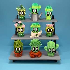 May include: A white ceramic mug with a black handle and the text "But First, Coffee" in a black, handwritten-style font. The mug is on a white surface.