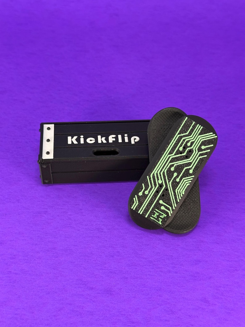 May include: Black skateboard deck with a green circuit board design and the word "Kickflip" on a black box. The skateboard decks are on a purple background.