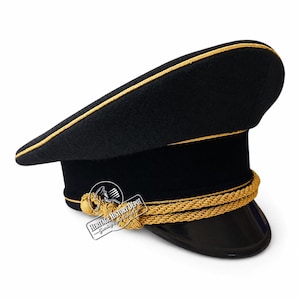 Könnte beinhalten: Eine schwarze Schirmmütze mit einer goldfarbenen geflochtenen Kordel auf der Vorderseite, einem schwarzen Schirm und goldener Paspelierung entlang der Oberkante. Ein kleines weißes rechteckiges Logo mit dem Text Heritage History Depot ist sichtbar.