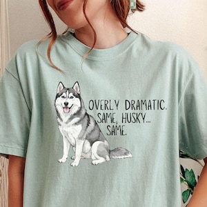 Könnte beinhalten: Hellgrünes T-Shirt mit einer Grafik eines grauen und weißen Siberian Husky. Der Text auf dem Shirt lautet: "OVERLY DRAMATIC. SAME, HUSKY... SAME."