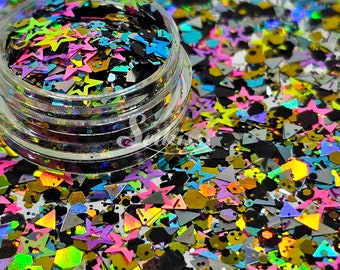 Pode incluir: Um frasco transparente cheio de glitter iridescente em várias formas, incluindo estrelas, triângulos e hexágonos. O glitter é uma mistura de preto, prata, ouro, rosa, azul e verde.