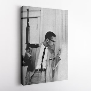 Op de afbeelding: Zwart-wit portret van een man in pak met een geweer. De man draagt een bril en een stropdas, kijkend naar rechts. De afbeelding is een canvas print.