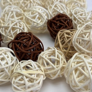 May include: A selection of decorative woven spheres in shades of brown and cream. The spheres are made from natural materials and are arranged in a close-up shot, highlighting their intricate woven patterns. These spheres are suitable for home decor.