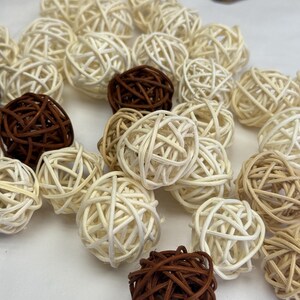 May include: A selection of decorative woven spheres in shades of brown and cream. The spheres are made from natural materials and vary in size, creating a textured, organic aesthetic. Suitable for home decor.