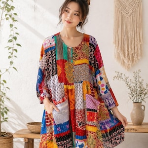 May include: A long-sleeved tunic featuring a vibrant patchwork design with various colorful patterns including floral, geometric, and abstract prints. The garment has a round neckline, a button-down front closure, and two large front pockets.