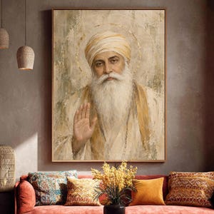 May include: A framed wall art print depicting a portrait of Guru Nanak Dev Ji with a long white beard and a turban. The figure is dressed in light-coloured robes, with one hand raised in a gesture of blessing, set against a textured, neutral background.