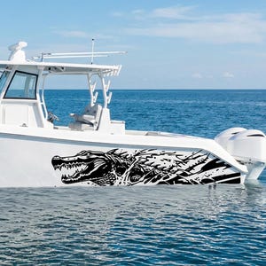 Puede incluir: Un barco a motor blanco con un gráfico de cocodrilo negro en el costado se ve en el agua. El barco tiene una cabina, un radar y dos motores fueraborda. El fondo es un cielo azul claro y el océano.