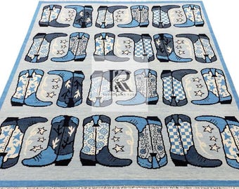 May include: A rectangular rug with a light blue background and a repeating pattern of cowboy boots in shades of blue, gray, and white. The boots feature various designs, including stars, floral patterns, and checkered patterns. The rug has a blue border.