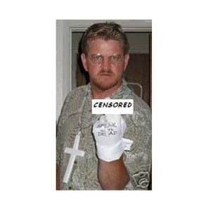 May include: A person wearing glasses and a patterned shirt, holding a white glove with the words "SPEAK WITH THE DEAD" printed on it. A white cross hangs around the person's neck. The word "CENSORED" is superimposed over the person's chest.