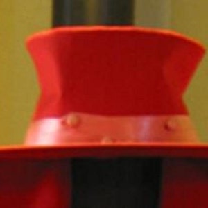 May include: A vibrant red hat with a wide brim and a slightly curved crown. The hat features a lighter red band around the base of the crown, adding a contrasting detail. The hat is a bold accessory.
