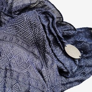 May include: A navy blue patterned scarf with a silver tag that says "Lola Rose".