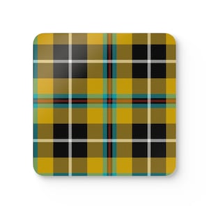 May include: A square coaster featuring a vibrant mustard yellow, black, and white tartan plaid pattern. The design includes thin intersecting lines in shades of turquoise, red, and cream, creating a symmetrical grid across the entire surface.