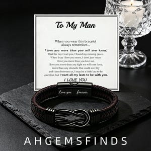 Puede incluir: Una pulsera de cuero trenzado marrón oscuro con un símbolo de infinito de metal negro y un cierre magnético grabado con las palabras Love you forever. Se muestra frente a una tarjeta blanca con el texto To My Man y un largo mensaje.