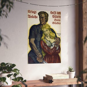 May include: A vintage propaganda poster featuring a man, a woman, and a child in a warm embrace. The text reads "Kriegs Anleihe" on the left and "Helft den Hütern Eures Glückes" on the right. The illustration uses muted tones of brown, red, and yellow.