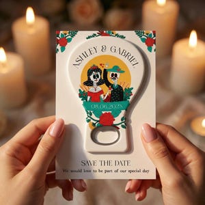 Peut inclure: Un ouvre-bouteille blanc avec un motif décoratif représentant un couple en tenue du Jour des Morts. L'ouvre-bouteille porte les noms "Ashley & Gabriel" et la date "08.06.202X", avec le texte "SAVE THE DATE" en dessous.