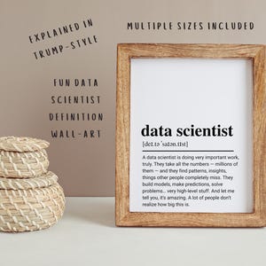 Peut inclure: Un cadre rectangulaire en bois contenant une impression blanche avec le texte data scientist et une définition écrite dans un style rhétorique spécifique. À côté du cadre se trouve une pile de trois paniers ronds en fibres naturelles tressées.