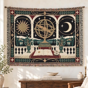 Peut inclure: Une tapisserie murale tissée rectangulaire représentant une sphère armillaire centrale, un soleil et un croissant de lune. Le motif comprend un livre ouvert avec des illustrations célestes, des plantes en pot et un fond sombre étoilé.