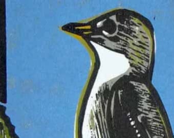 May include: A black and white woodblock print of a bird perched on a branch of green leaves against a blue background. The bird has a white throat and a black body with white markings. The print is signed "Gwen Jamusk" and dated "Copyright 2016".