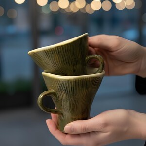 handmade ceramic mug, pottery coffee cup, artisan stoneware mug, rustic green mug, handmade tea cup, unique ceramic drinkware, textured pottery mug, flared ceramic cup, handcrafted kitchenware, ceramic espresso mug, artisan coffee mug, handmade pottery gift, rustic home décor, ceramic tableware, green ceramic cup, handmade mug set, pottery lover gift, artisan drinkware, ceramic cappuccino mug, rustic ceramic piece, handmade coffee cup, wheel thrown mug, ceramic art mug, eco friendly mug