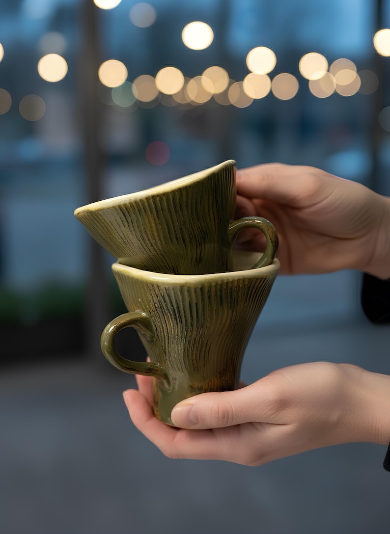 handmade ceramic mug, pottery coffee cup, artisan stoneware mug, rustic green mug, handmade tea cup, unique ceramic drinkware, textured pottery mug, flared ceramic cup, handcrafted kitchenware, ceramic espresso mug, artisan coffee mug, handmade pottery gift, rustic home décor, ceramic tableware, green ceramic cup, handmade mug set, pottery lover gift, artisan drinkware, ceramic cappuccino mug, rustic ceramic piece, handmade coffee cup, wheel thrown mug, ceramic art mug, eco friendly mug