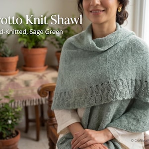 May include: A sage green hand-knitted shawl featuring a textured garter stitch body and a decorative cable knit border along the edge. The text Grotto Knit Shawl and Hand-Knitted, Sage Green is printed in white on the upper left side of the image.