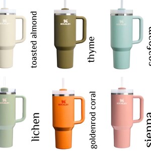 Peut inclure: Collection de gobelets isothermes de diff&eacute;rentes couleurs : amande grill&eacute;e, thym, &eacute;cume de mer, lichen, corail dor&eacute; et terre de Sienne. Chaque gobelet est dot&eacute; d'une poign&eacute;e, d'une paille et d'un couvercle argent&eacute;. Le logo Stanley est visible.