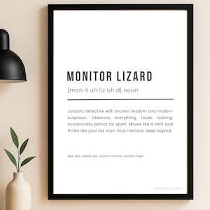 May include: A black framed print featuring the words "MONITOR LIZARD" in bold, black text. The definition describes the monitor lizard as a "Jurassic detective." The print also includes the text "DEFINED & CO. EST 2025" at the bottom.