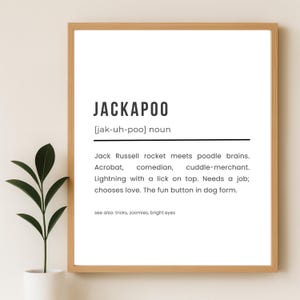 May include: A framed print with the word "JACKAPOO" in bold black letters. Below, the definition describes a Jack Russell and poodle mix. The text includes phrases like "fun button in dog form."