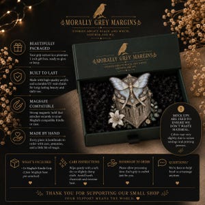 May include: A black gift box containing a MagSafe grip featuring a metallic knight helmet adorned with a large white moth and a white lily. The box lid displays the text Morally Grey Margins and Stories Aren't Black and White, Neither Are We.
