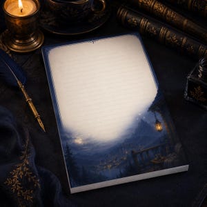 May include: A rectangular notepad with lined white paper featuring a dark blue border and a printed illustration at the bottom showing a mountain landscape at night with a glowing lantern, a full moon, and a small village nestled in the valley.