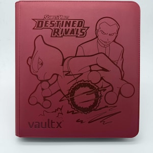 Può includere: Un raccoglitore di carte collezionabili Vault X rosso con il logo "Scarlet & Violet Destined Rivals" e opere d'arte di un personaggio e un Pokémon. Il raccoglitore ha un logo Vault X in rilievo in basso.
