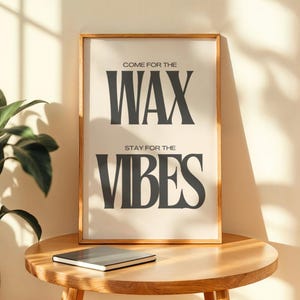 Puede incluir: Una l&aacute;mina de arte mural rectangular en un marco de madera clara con el texto negro COME FOR THE WAX STAY FOR THE VIBES centrado sobre un fondo crema. La tipograf&iacute;a utiliza una fuente serif en negrita con las palabras WAX y VIBES ampliadas.