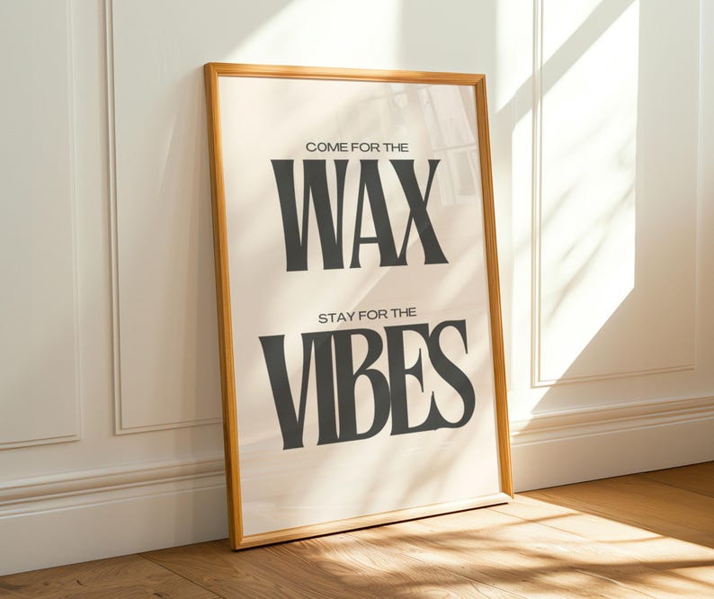 Puede incluir: Un p&oacute;ster rectangular en un marco de madera clara con fondo color crema y texto gris oscuro. El texto dice "COME FOR THE WAX" en la parte superior y "STAY FOR THE VIBES" en la parte inferior con una tipograf&iacute;a serif audaz.