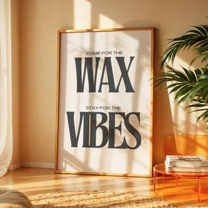 Puede incluir: Una l&aacute;mina de arte mural rectangular en un marco dorado fino con el texto negro COME FOR THE WAX STAY FOR THE VIBES sobre un fondo blanco. La tipograf&iacute;a es negrita y con serifa, centrada en la impresi&oacute;n, con la palabra WAX m&aacute;s grande.