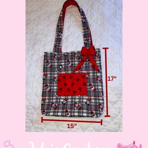 May include: A handmade tote bag with a gray plaid pattern featuring Mickey Mouse. The bag has red accents, including a bow and a pocket with a Mickey Mouse pattern. It measures 15 inches wide and 17 inches tall.