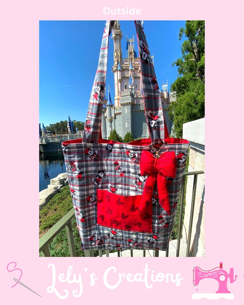 May include: A gray, red, and white plaid tote bag with a red bow and a red pocket featuring Mickey Mouse silhouettes. The bag has long straps and is set against a backdrop of a castle and blue sky.