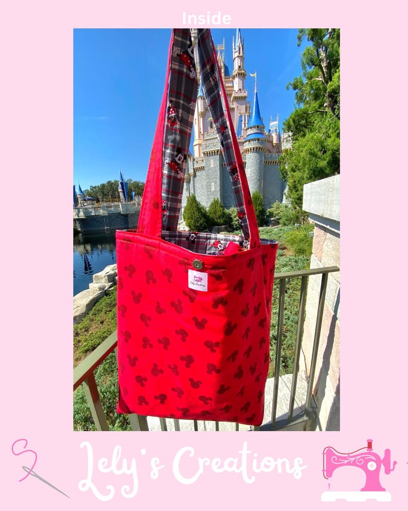 May include: Red tote bag with black Mickey Mouse silhouettes. The bag has a plaid lining and long straps. The text "Inside" is at the top. The bag is displayed in front of a castle.