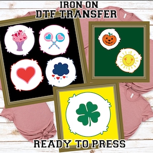 May include: Iron-on DTF transfer designs featuring cartoon graphics. The designs include a heart, a cloud with hearts, a pumpkin, a smiling sun, a clover, and lollipops. The text "READY TO PRESS" is visible.