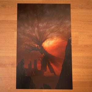 May include: A poster featuring a dramatic fantasy landscape with a large, gnarled tree silhouetted against a fiery sunset. Dark, jagged rock formations frame a distant city. The color palette is dominated by shades of red, orange, and black.