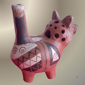 Puede incluir: Escultura de cerámica de un animal marrón rojizo con cuello largo y cabeza con múltiples agujeros. El cuerpo está decorado con patrones geométricos negros, blancos y marrones. Tiene tres patas pequeñas y un pico.