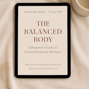 May include: A digital tablet displays a beige-colored document titled "THE BALANCED BODY" with the subtitle "A Beginner's Guide to Natural Feminine Wellness." The text is in brown. A small ceramic cup sits to the right.