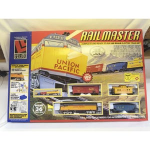 May include: A boxed Rail Master HO scale electric train set. The box features a yellow Union Pacific locomotive and several train cars. The set includes a giant 91 cm track circle and over 100 pieces. The box also includes a power pack and road signs.
