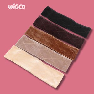 Puede incluir: Una colección de cintas para sujetar pelucas en varios colores, incluyendo negro, marrón, beige y arena. Cada cinta está hecha de un material suave, similar al terciopelo, con un patrón de diamantes acolchado. La marca "wigco" es visible.