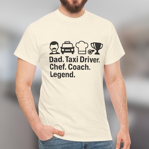 Könnte beinhalten: Cremefarbenes T-Shirt mit schwarzen grafischen Symbolen und Text. Die Symbole umfassen einen Schnurrbart, ein Taxi, eine Kochmütze und eine Trophäe. Der Text lautet: "Dad. Taxi Driver. Chef. Coach. Legend."