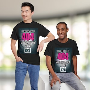Könnte beinhalten: Schwarze T-Shirts mit dem Aufdruck "ERROR 404 MOTIVATION NOT FOUND" in Pink und Weiß. Das Design zeigt ein trauriges Computer-Symbol. Die T-Shirts werden von zwei Personen getragen.